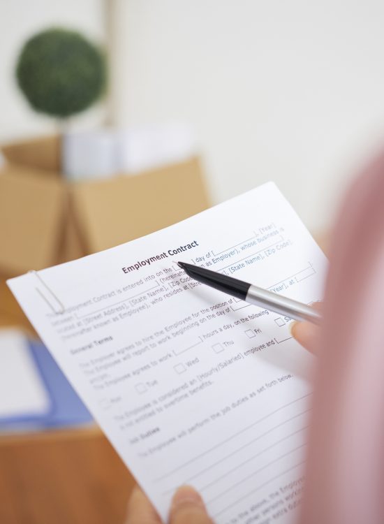 Close-up image of businesswoman reading employment contract and checking details